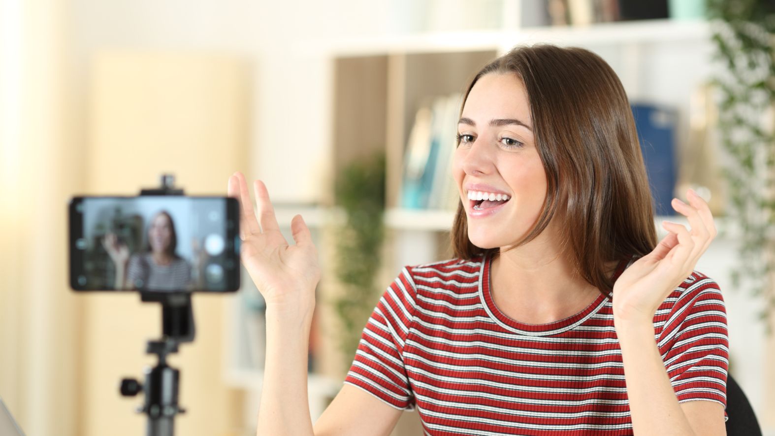 Picture of girl in a red shirt talking in front of a camera